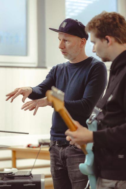 Dozent erklärt den Musiker*innen Bestandteile der Songs