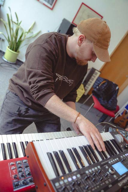 Ein Musiker spielt Keyboard im Proberaum des Complete Music Camps