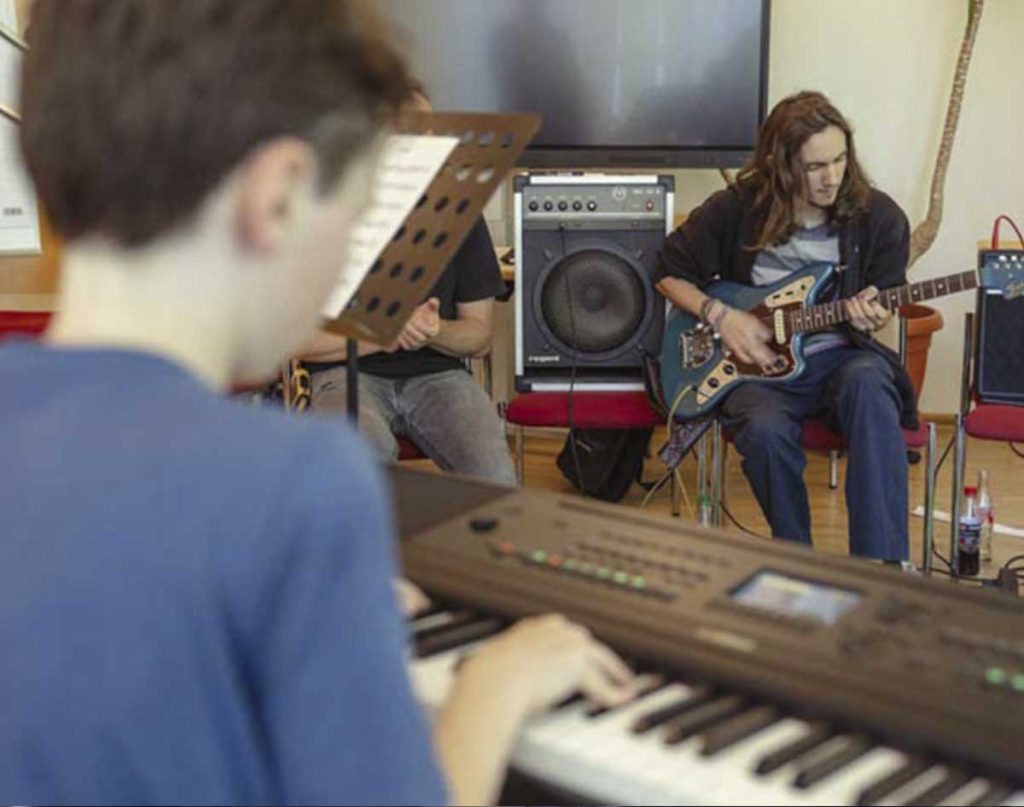 Einblick in den Proberaum mit Gitarrist und Pianist beim Complete Music Camp